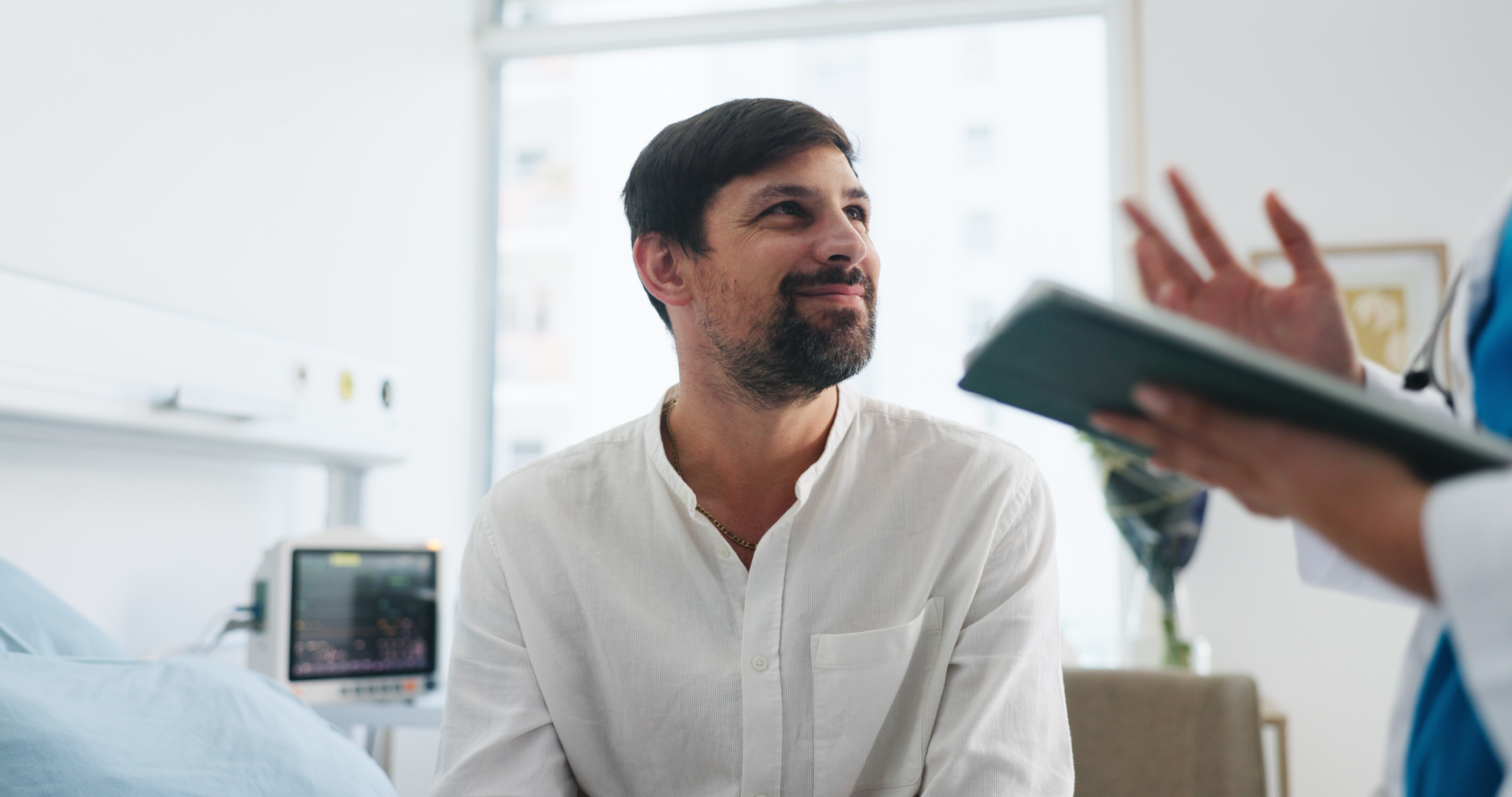 A patient in a relaxed, attentive conversation with his practitioner