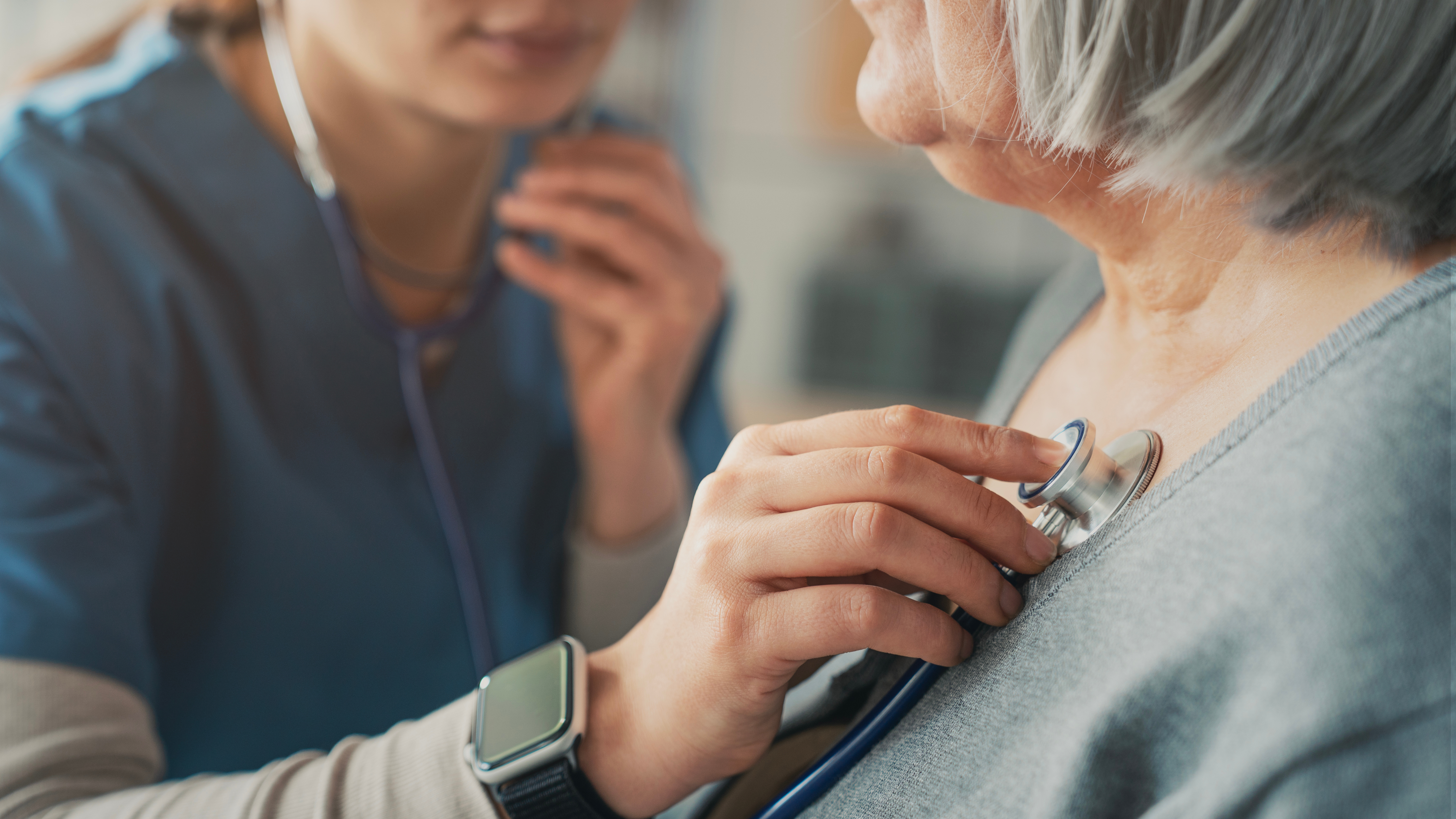 Clinician with a stethoscope listening closely &mdash; attentive, investigative care